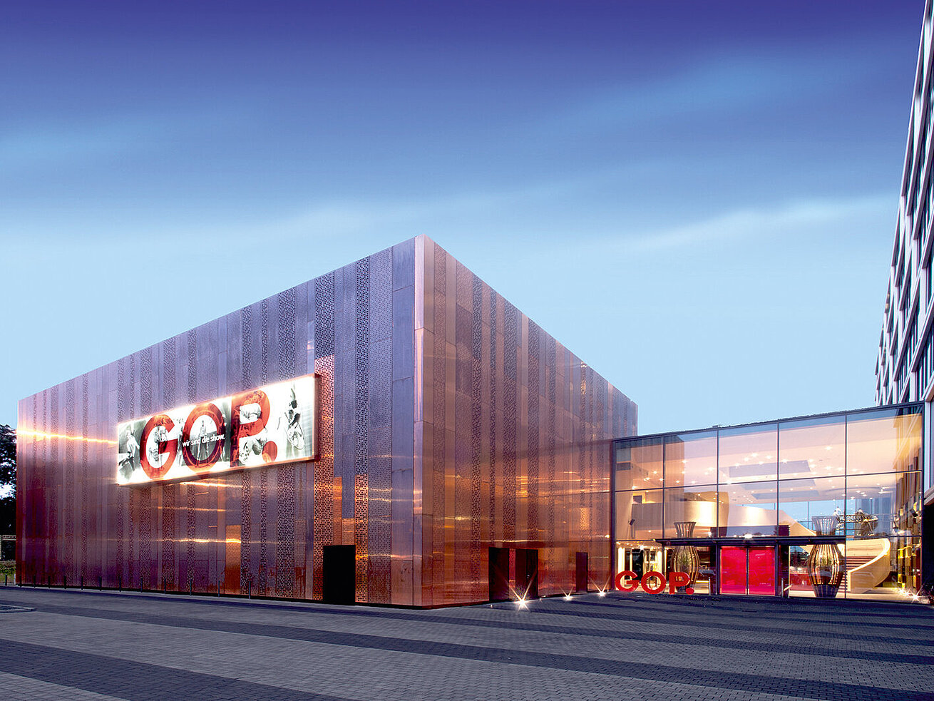 Modern building of GOP Varieté theatre with illuminated facade at dusk