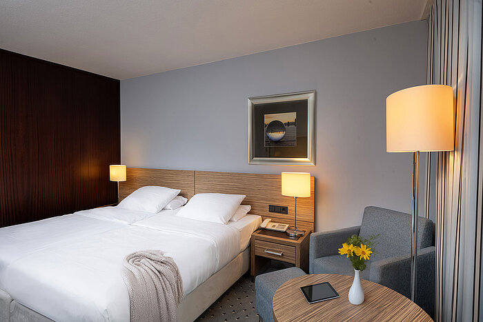 Cozy seating area and comfortable bed in the Comfort room of the Maritim Hotel Darmstadt