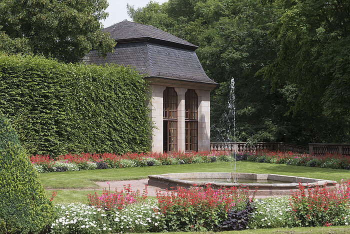 Historic pavilion in the blooming garden of Maritim Hotel Fulda with water feature and fountain.