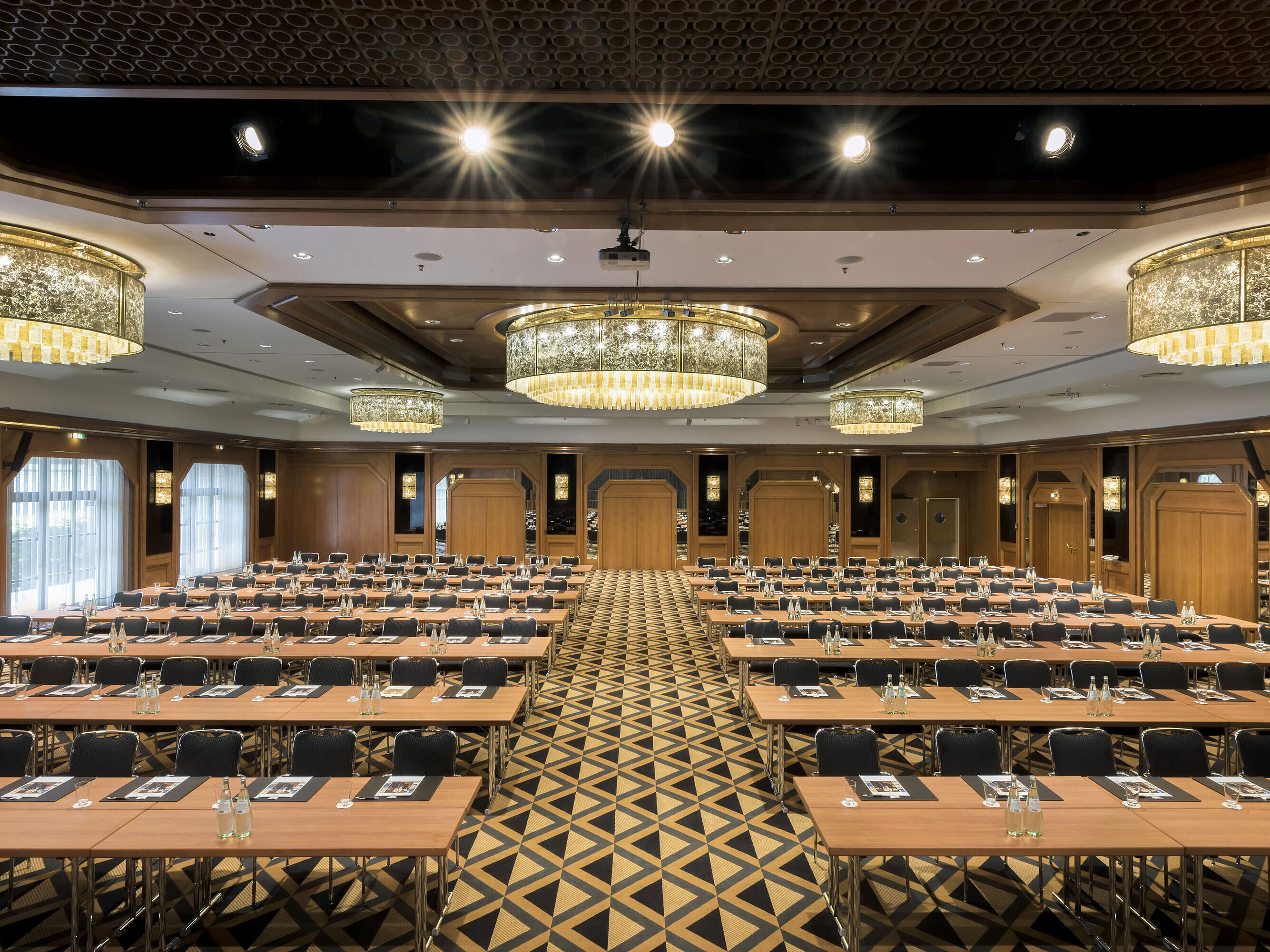 Elegant conference hall with stage, chandeliers, and modern seating at Maritim Hotel Königswinter.