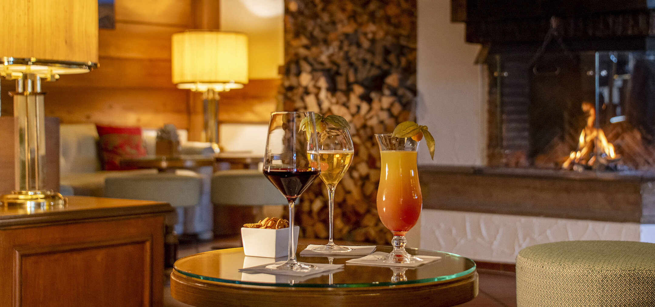 Wine, beer and cocktail on a table in front of the cosy fireplace at the Maritim Hotel Titisee bar