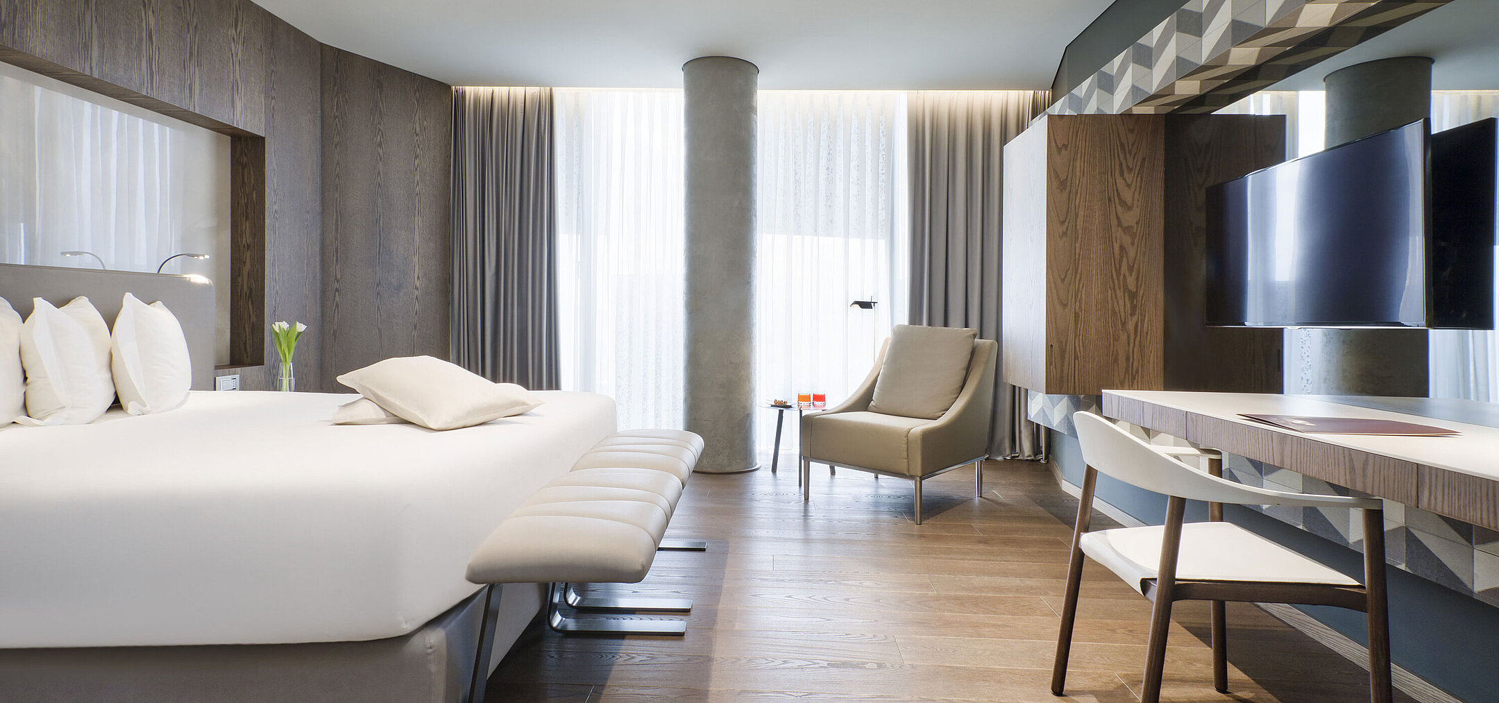 Bright room at Maritim Hotel Plaza Tirana with desk, large bed and wooden flooring