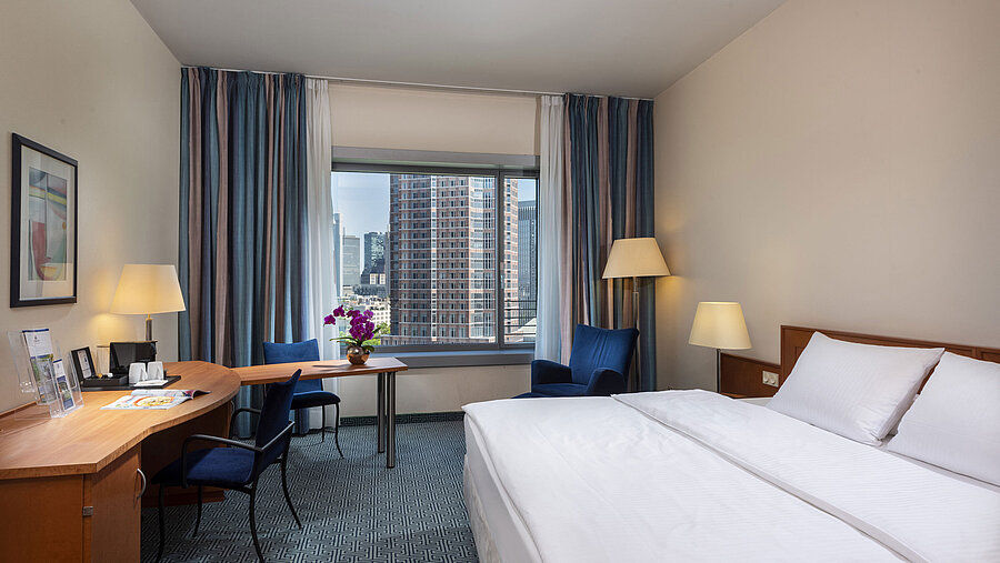 Superior room at Maritim Hotel Frankfurt with a double bed, desk, and view of the Frankfurt skyline.