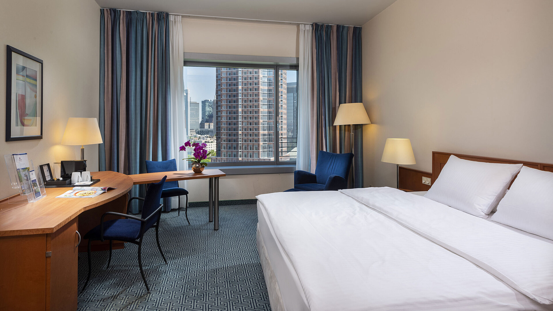 Superior room at Maritim Hotel Frankfurt with a double bed, desk, and view of the Frankfurt skyline.
