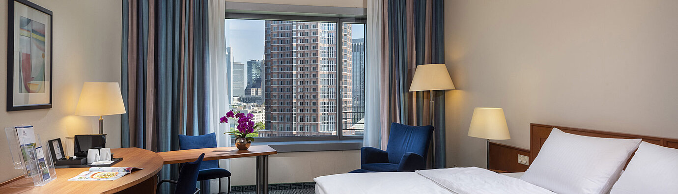 Superior room at Maritim Hotel Frankfurt with a double bed, desk, and view of the Frankfurt skyline.