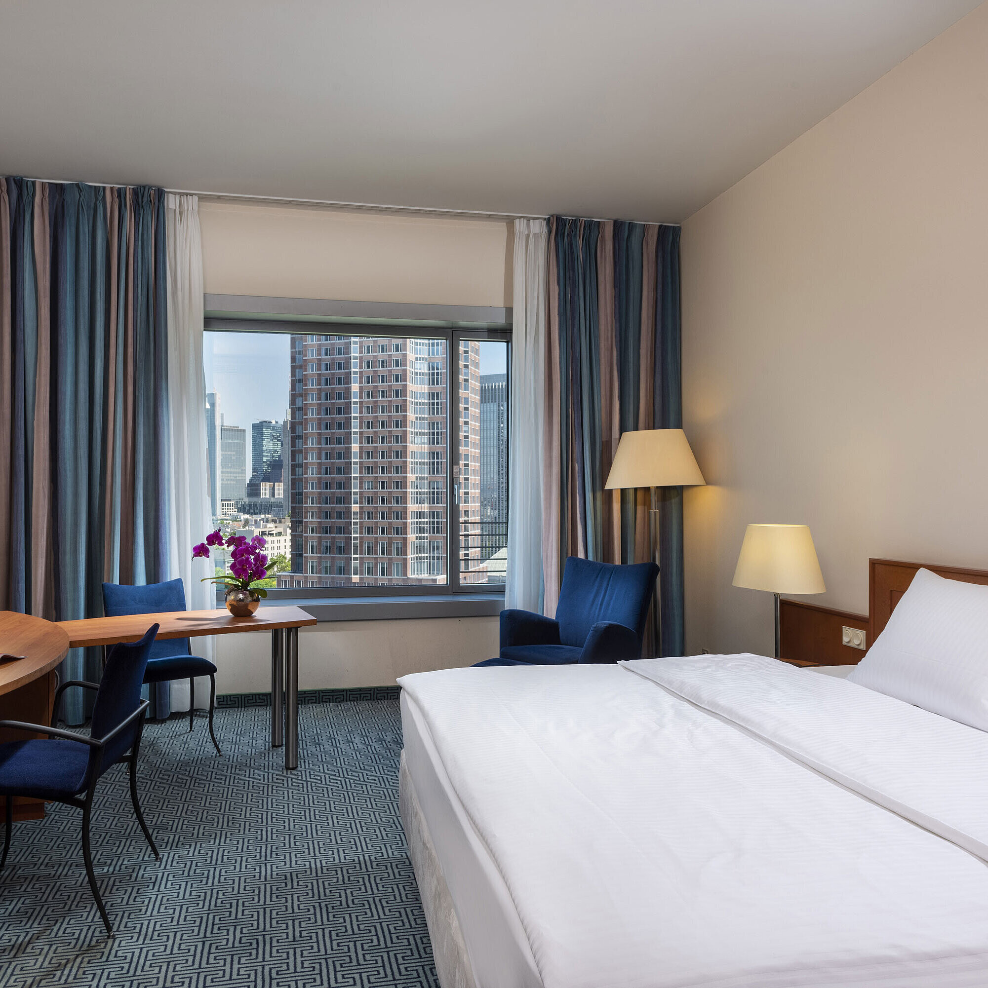 Superior room at Maritim Hotel Frankfurt with a double bed, desk, and view of the Frankfurt skyline.