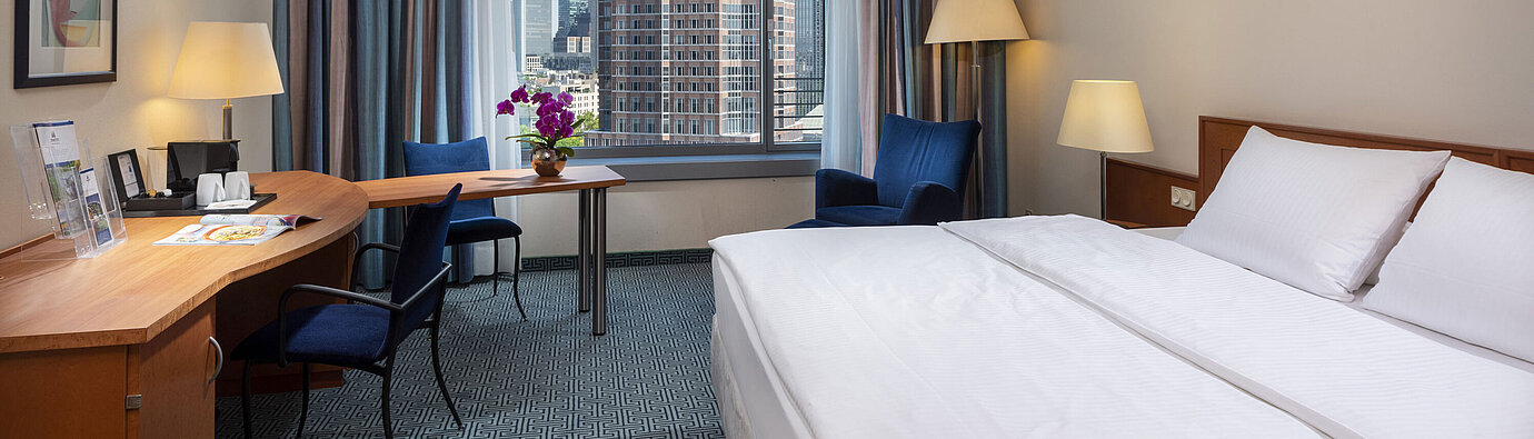 Superior room at Maritim Hotel Frankfurt with a double bed, desk, and view of the Frankfurt skyline.