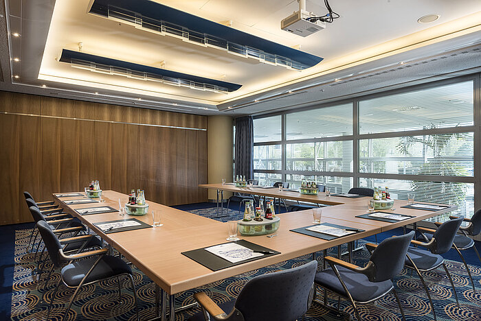Small meeting room at Maritim Hotel Frankfurt with U-shaped seating, natural light, and modern technology for meetings.