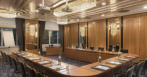 U-shaped meeting room with elegant chairs, projectors and chandeliers at Maritim Hotel Stuttgart