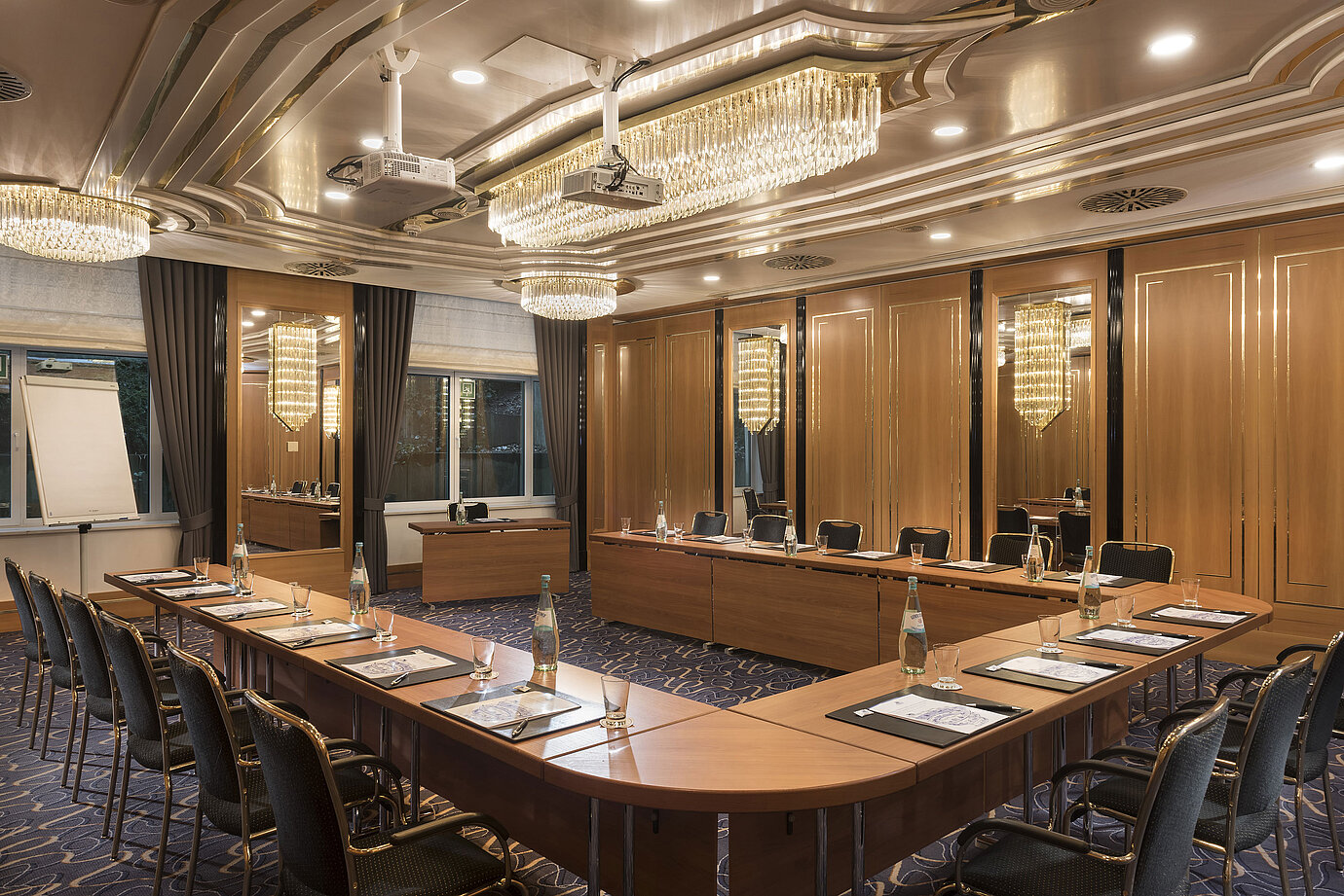 U-shaped meeting room with elegant chairs, projectors and chandeliers at Maritim Hotel Stuttgart