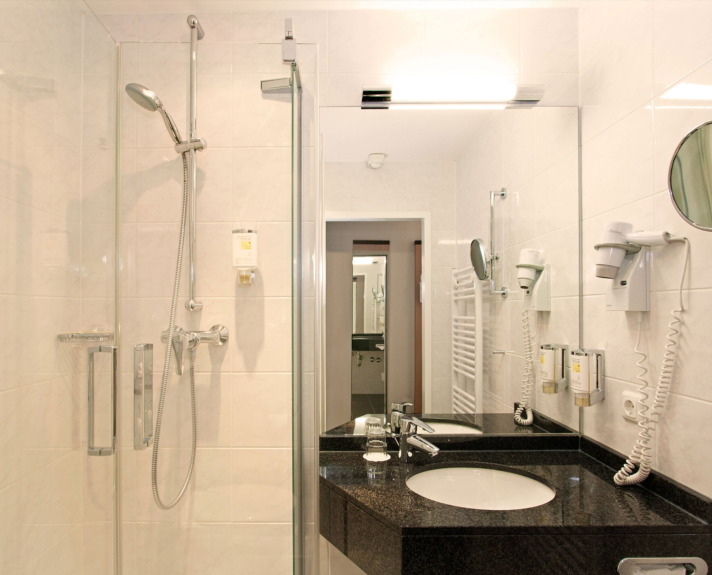 Modern bathroom with shower, washbasin and mirror at Hansa Hotel Wiesbaden