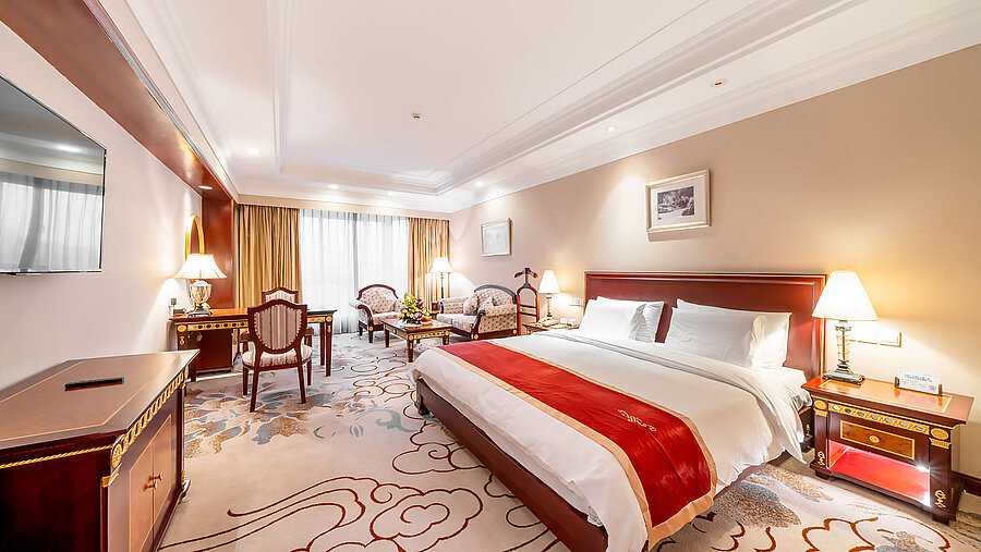 寬敞的經典酒店客房配備特大床、休憩區、書桌及暖色照明，為您打造舒適的住宿體驗