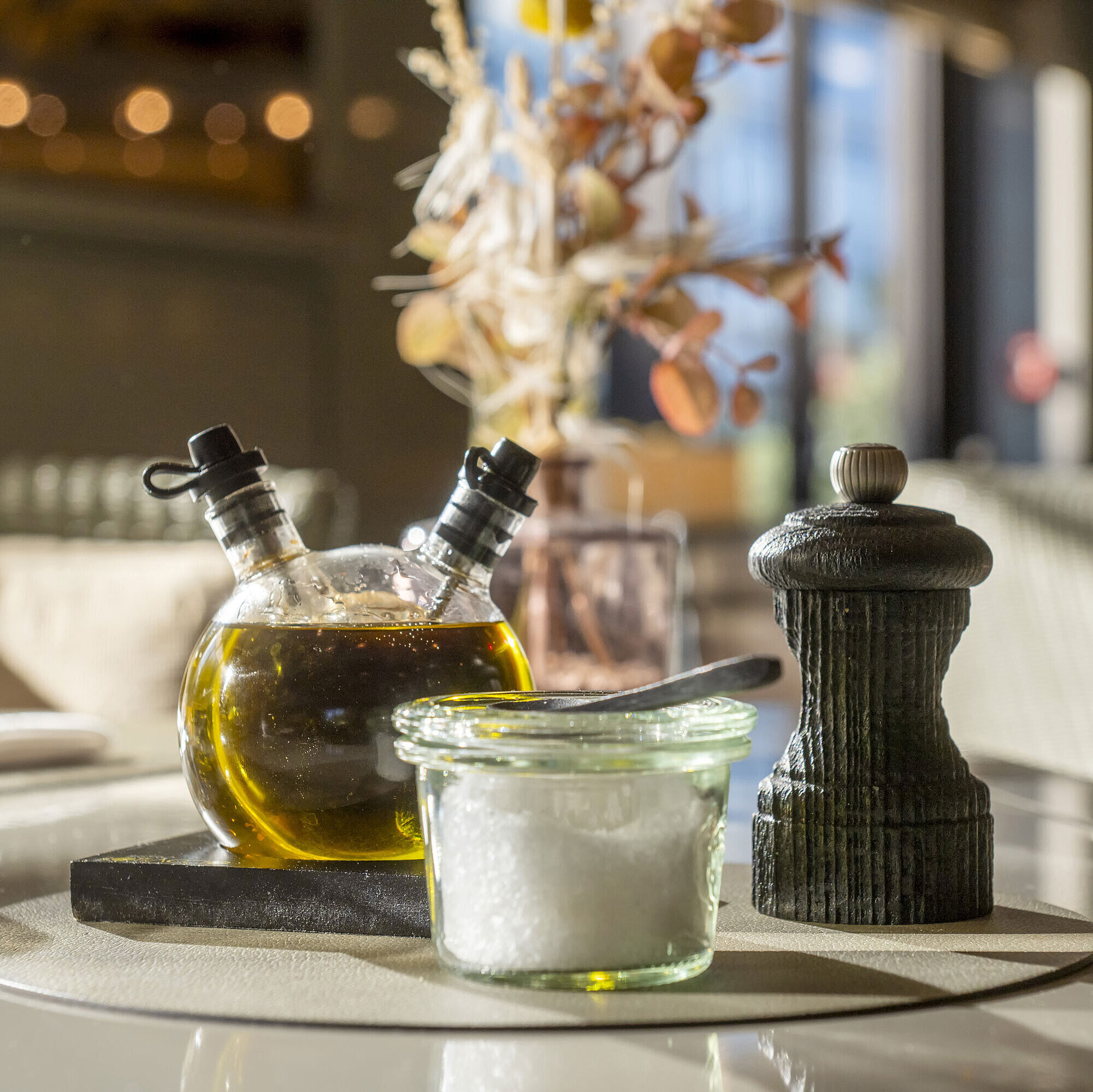 Close-up of a set table at Maritim Hotel Düsseldorf with olive oil, salt, and pepper grinder.