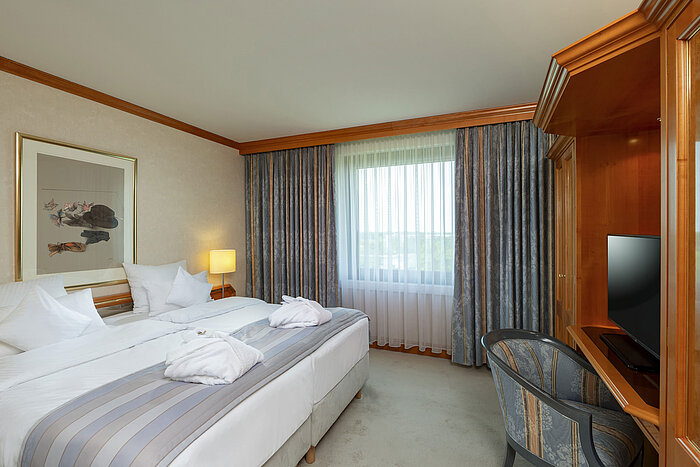 Bright double room at Maritim Hotel Hannover with cozy bed and desk.