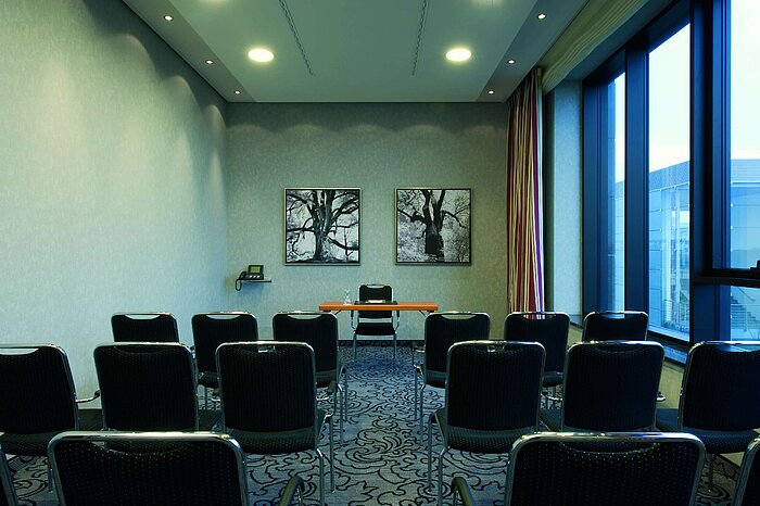 Small conference room at Maritim Hotel Düsseldorf with modern seating, natural light, and minimalist design.