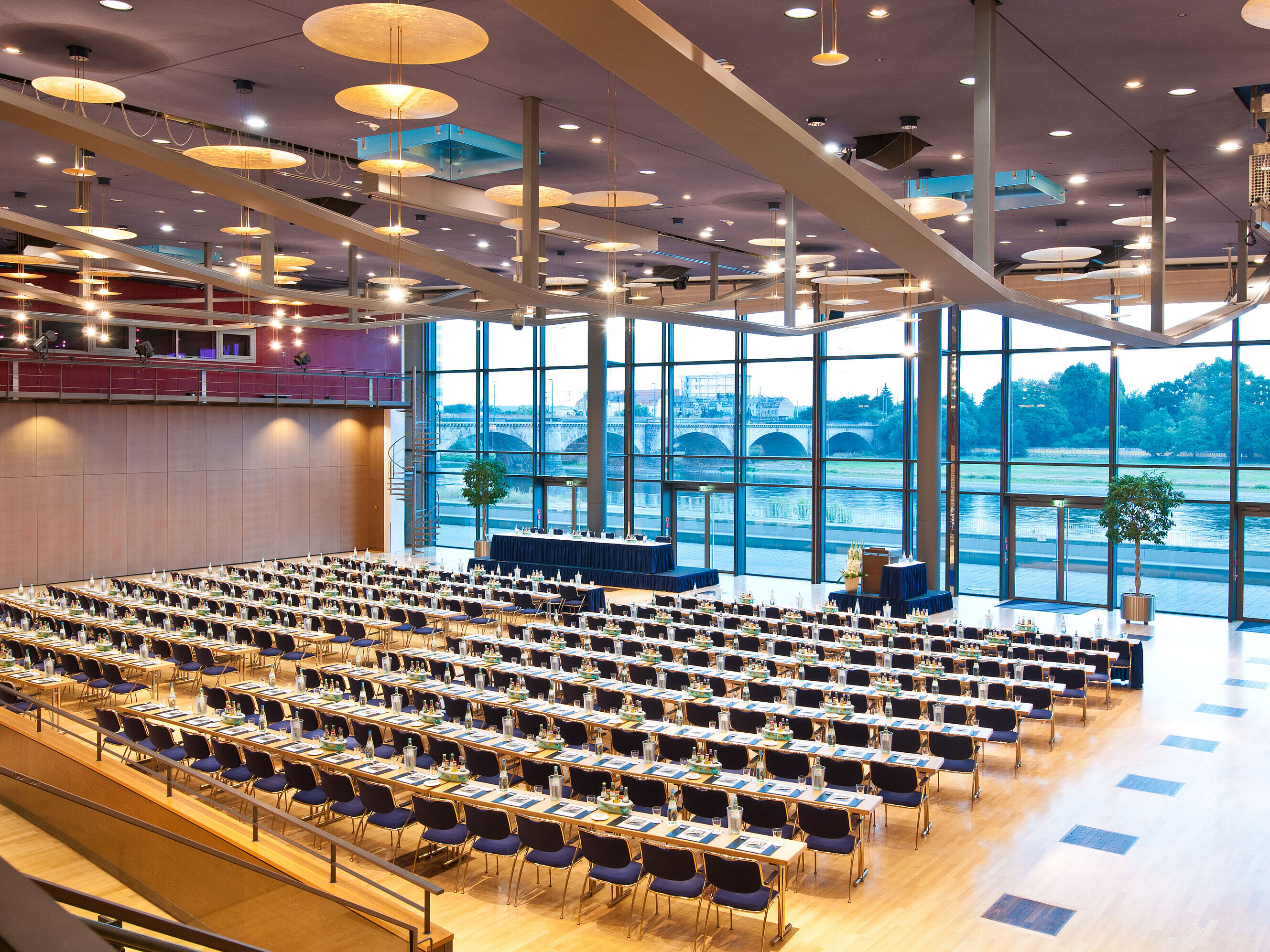 Large conference hall in Maritim Hotel Dresden with rows of blue chairs and a view of the Elbe River.