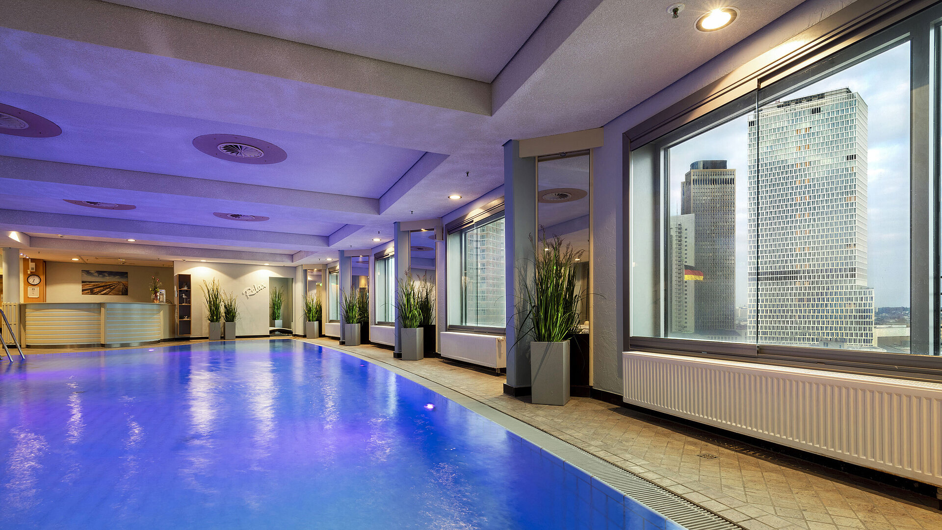 Illuminated indoor pool at Maritim Hotel Frankfurt with a relaxing atmosphere and panoramic windows.
