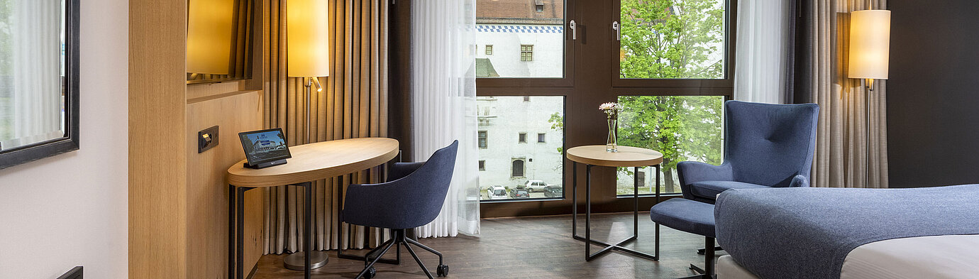 Modernly furnished hotel room at Maritim Hotel Ingolstadt with a desk and city view.
