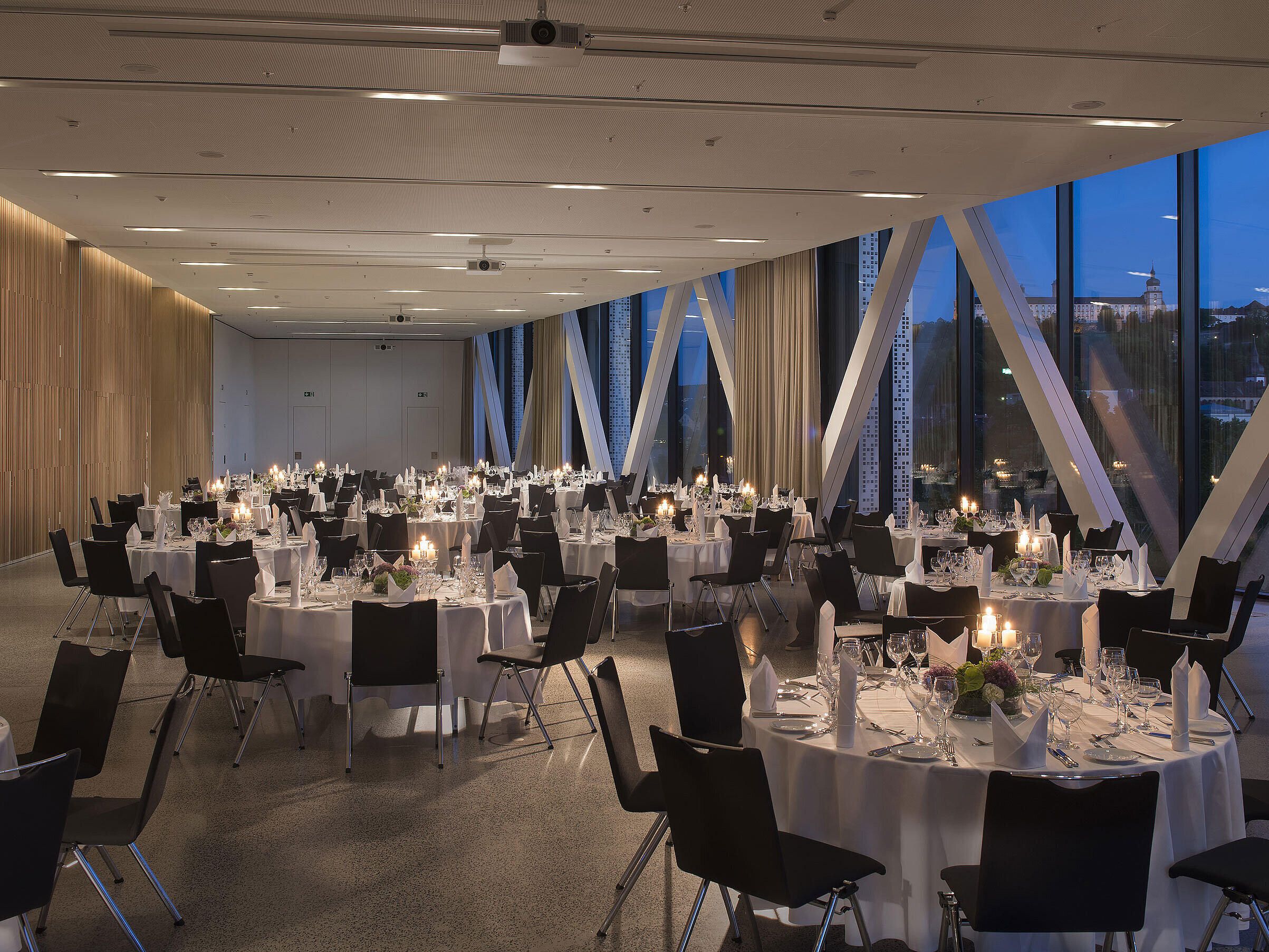Elegant event venue at Maritim Hotel Würzburg with round tables and view of the fortress