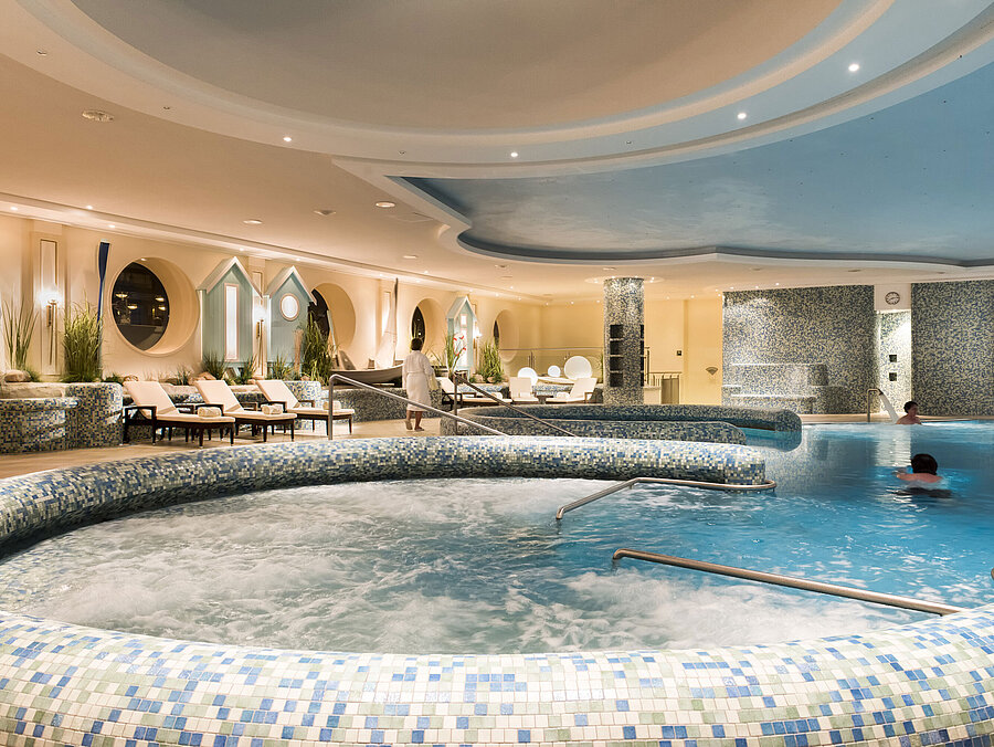 Spacious wellness pool area with whirlpool and loungers at the Maritim Seehotel Timmendorfer Strand.