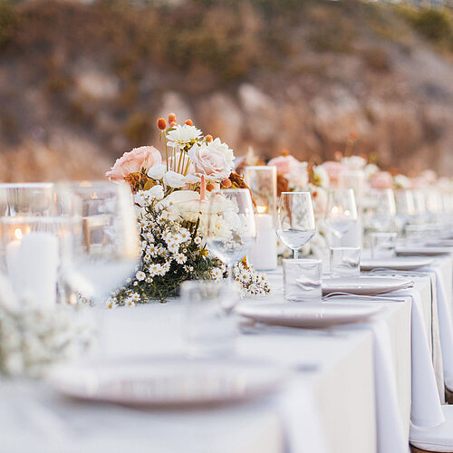 Festive outdoor table at Maritim Resort Marina Bay with flowers, candles and coastal views