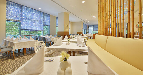 Bright restaurant with large windows, white-set tables and modern design for a relaxed dining atmosphere