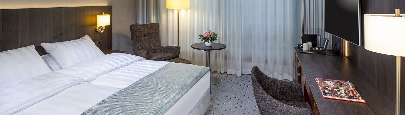 Modern Superior double room at Maritim Hotel Bremen with seating area, desk, and large window for natural light.