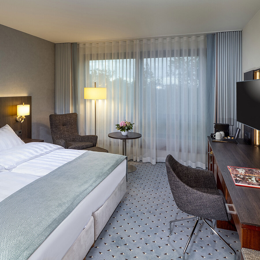 Modern Superior double room at Maritim Hotel Bremen with seating area, desk, and large window for natural light.