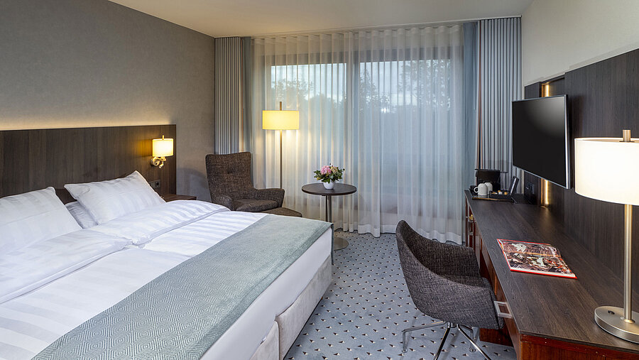 Modern Superior double room at Maritim Hotel Bremen with seating area, desk, and large window for natural light.