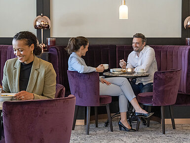 Guests enjoy a cozy coffee break in the stylish lounge at Maritim Hotel Ingolstadt.