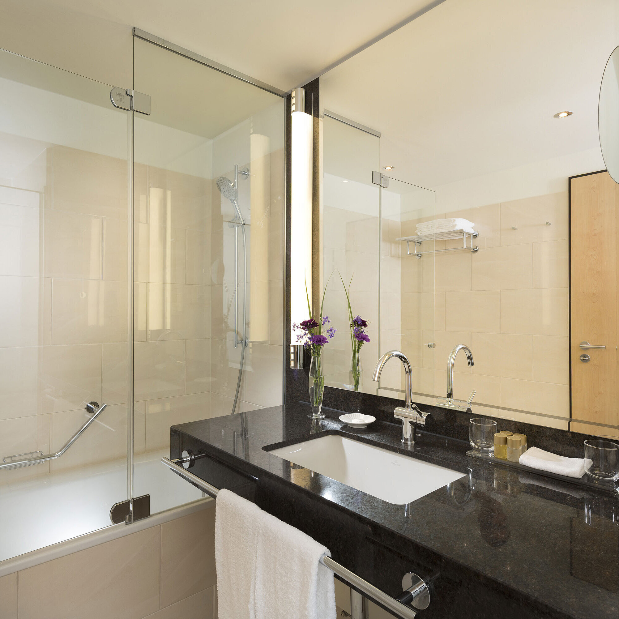 Elegant bathroom at Maritim Hotel Düsseldorf with large bathtub, mirror, sink, and modern fixtures.