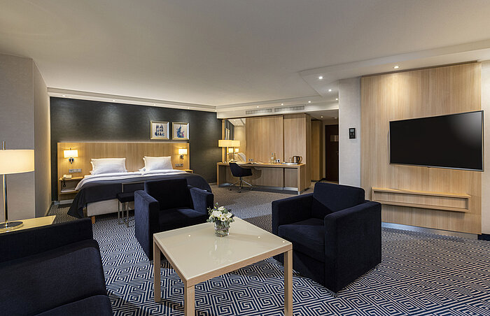 Spacious Junior Suite at Maritim Hotel Würzburg with double bed, seating area and modern design