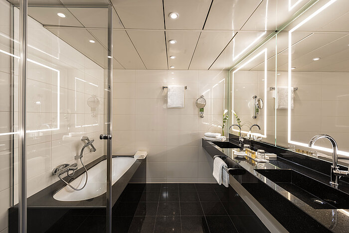 Spacious suite bathroom with modern bathtub, double sinks, and elegant lighting at the Maritim Hotel Bonn.
