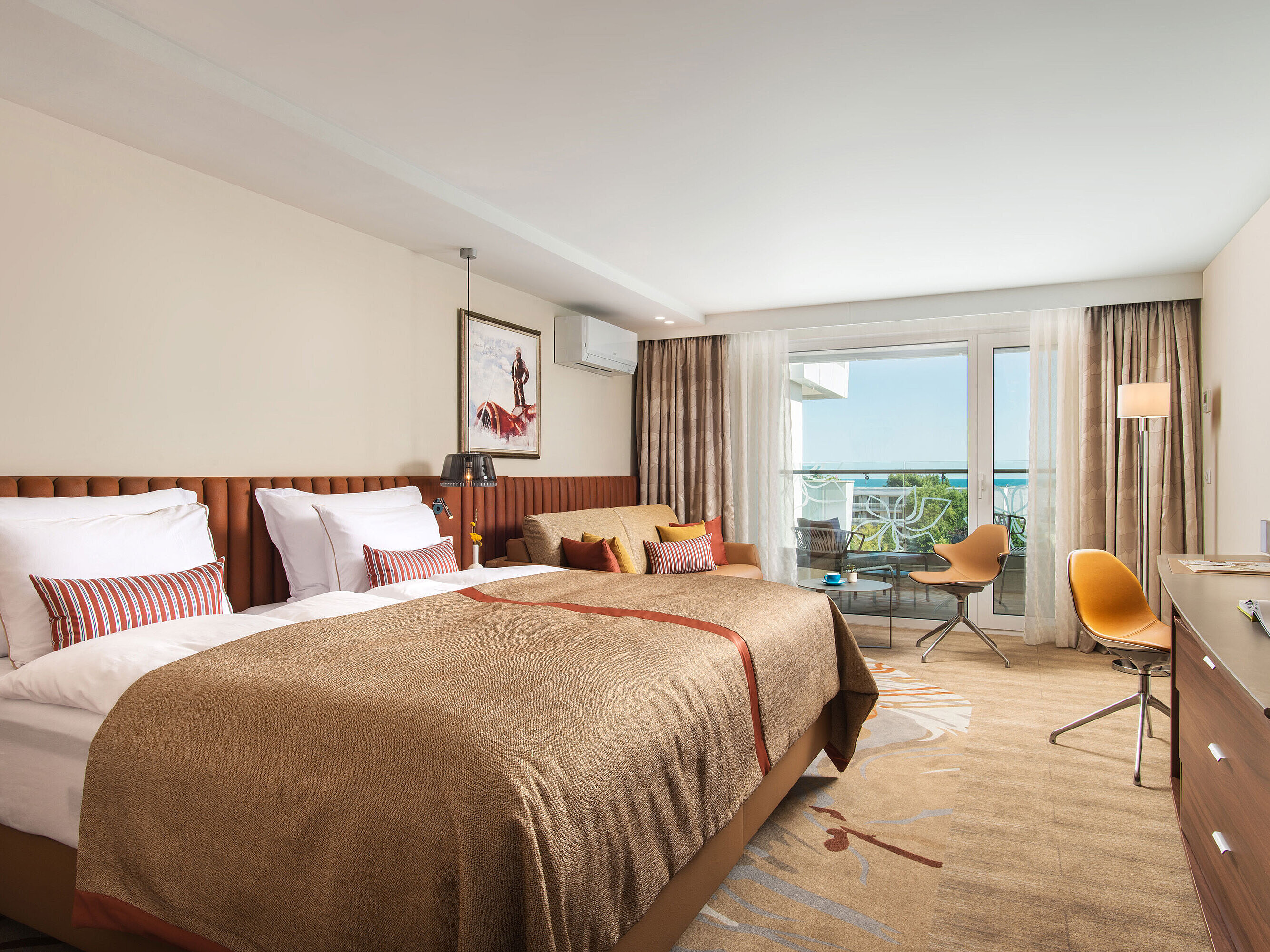 Spacious room at Maritim Hotel Amelia with cosy bed, seating area and balcony overlooking greenery