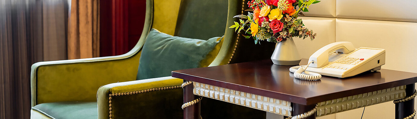 優雅的休憩區配有綠色扶手椅、邊桌及鮮花擺設