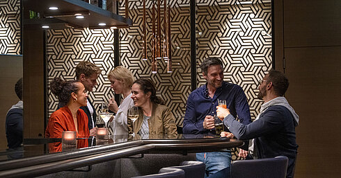 Guests enjoy drinks and lively conversations in the stylish bar at Maritim Hotel Ingolstadt.
