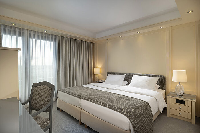 Luxurious bedroom in a suite at Maritim Hotel Darmstadt with a cozy double bed and classic design.