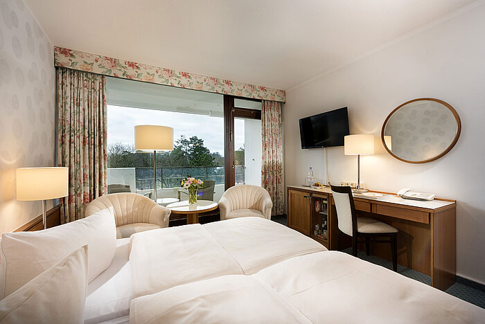 Classic room at Maritim Seehotel Timmendorfer Strand with balcony, double bed, seating area, TV, and desk.