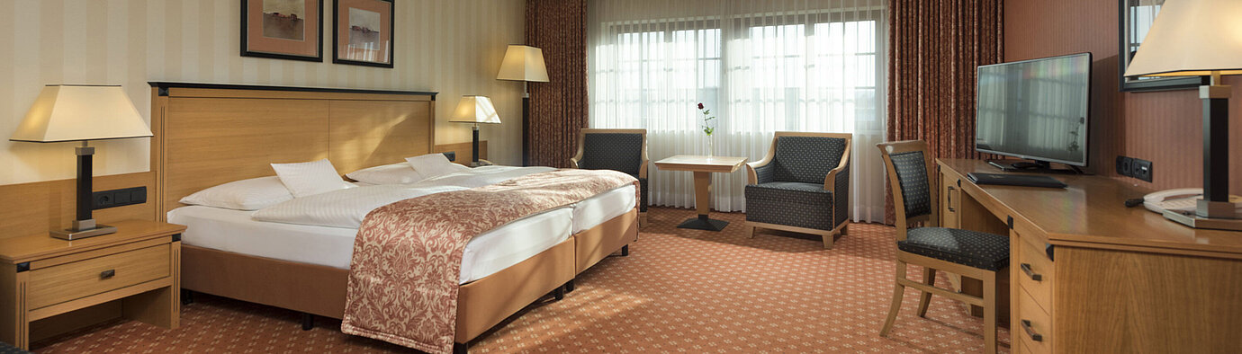 Classic room at Maritim Hotel Dresden with double bed, seating area, and classic decor.