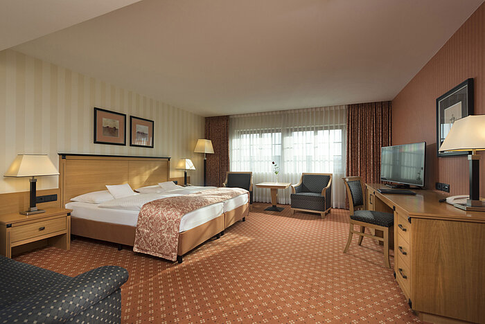 Classic room at Maritim Hotel Dresden with double bed, seating area, and classic decor.