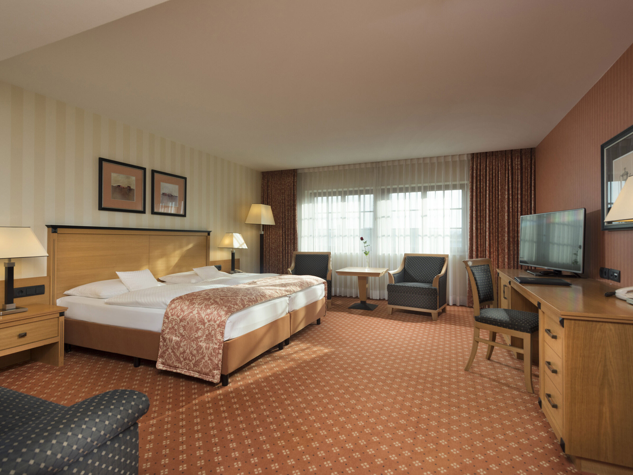 Classic room at Maritim Hotel Dresden with double bed, seating area, and classic decor.