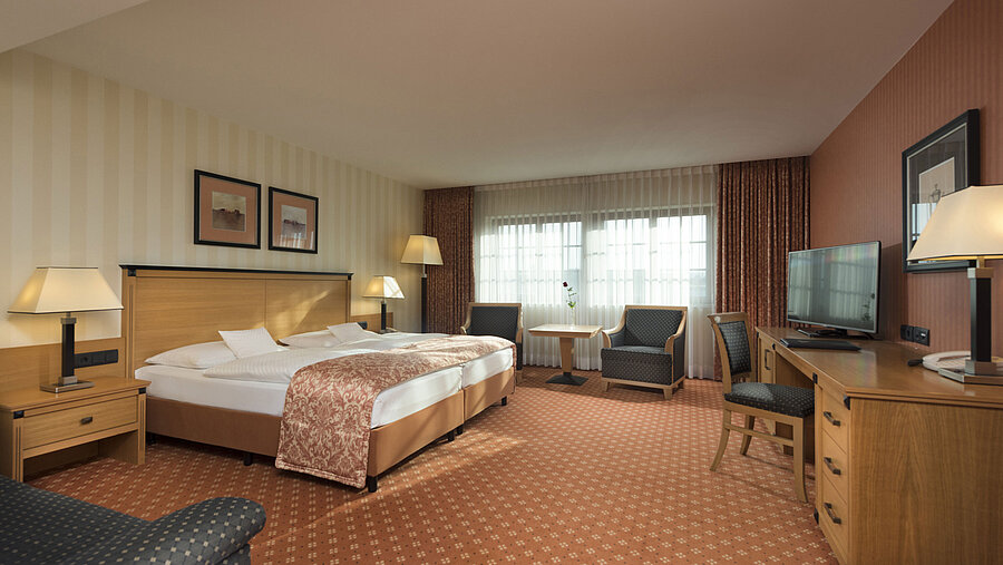 Classic room at Maritim Hotel Dresden with double bed, seating area, and classic decor.