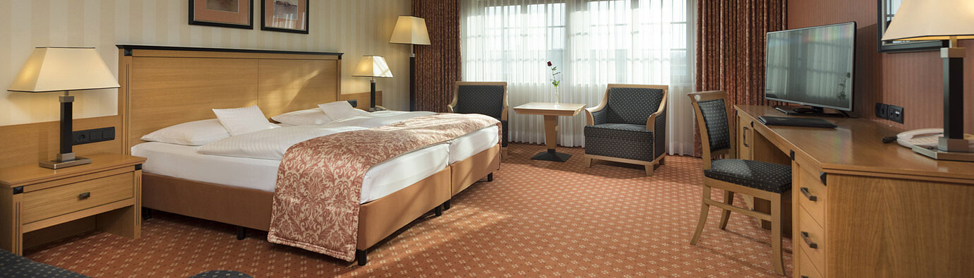 Classic room at Maritim Hotel Dresden with double bed, seating area, and classic decor.