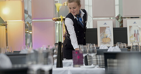 Staff member elegantly sets the table in the restaurant at the Maritim Hotel Munich