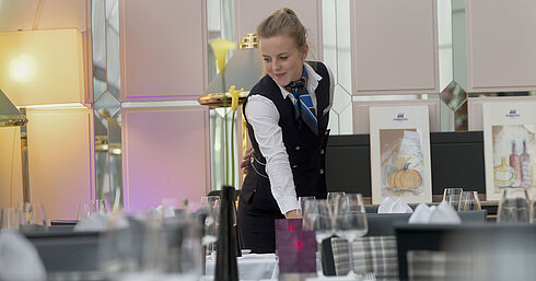 Staff member elegantly sets the table in the restaurant at the Maritim Hotel Munich