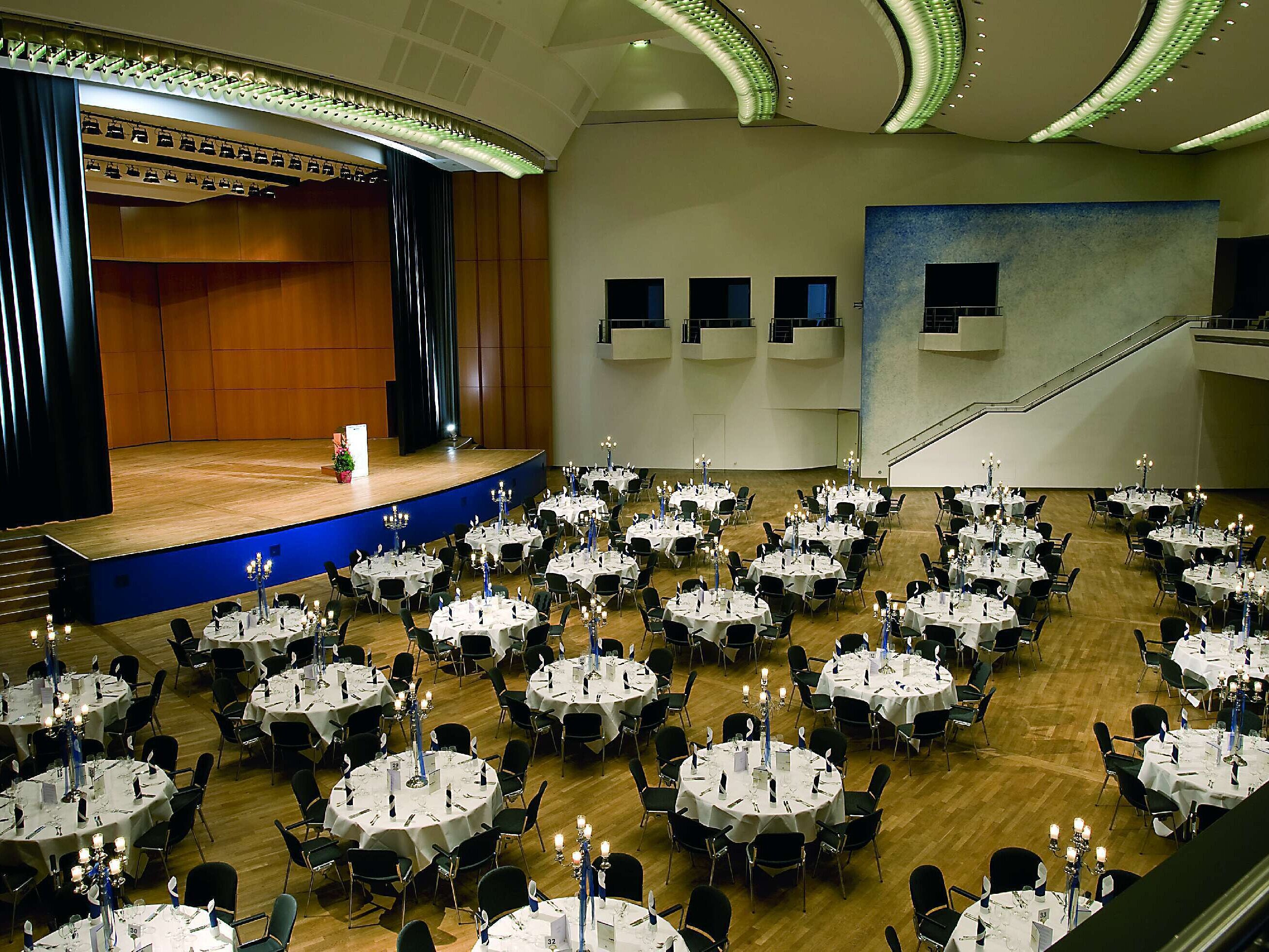 Large event hall at Maritim Hotel Ulm with stage and banquet seating for festive occasions