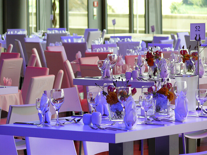 Close-up of elegantly set tables with floral arrangements in the event room at Maritim Hotel Dresden.