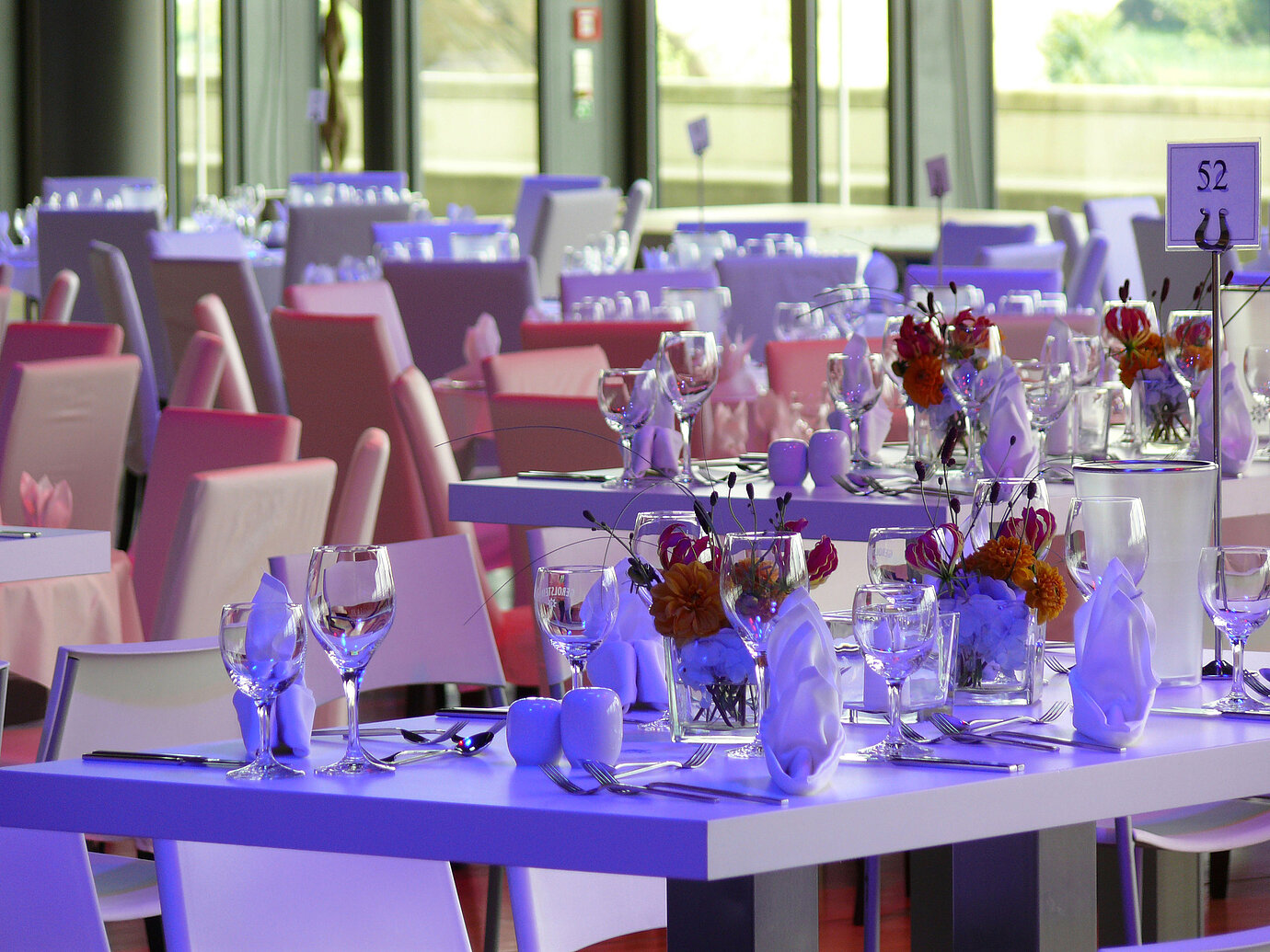 Close-up of elegantly set tables with floral arrangements in the event room at Maritim Hotel Dresden.