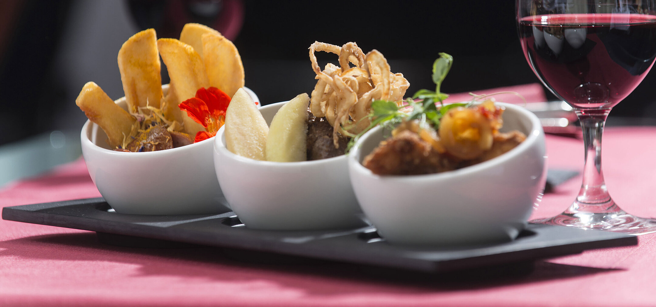 Close-up of tapas at Maritim proArte Hotel Berlin,featuring a variety of delicacies with a glass of red wine in the background