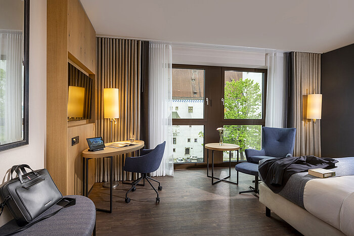 Modernly furnished hotel room at Maritim Hotel Ingolstadt with a desk and city view.